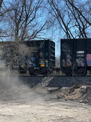 Gritty train vibes under a clear blue sky.